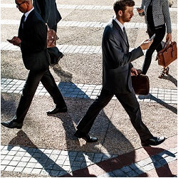 businessmen walking and staring at phones