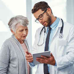 A doctor reviews health records with a patient.