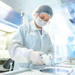 A researcher reviews a 200 mm Silicon III-V wafer. 