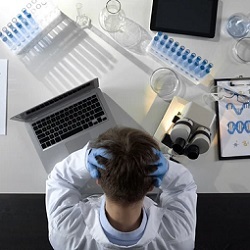 chemist holding his head 