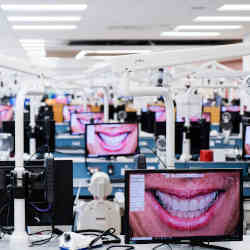 In a dental college classroom, software shows how patients will look after treatment.