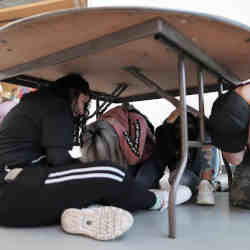 Students participate in an earthquake drill.