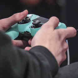 A gamer holds a Playstation 4 controller.