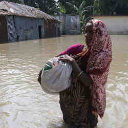 A woman walking through flood waters in Bangladesh last July.