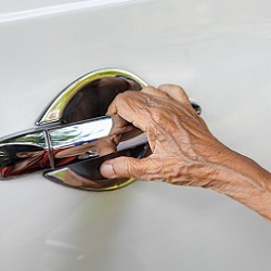hand of elderly person on car door handle