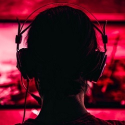 video gamer wearing headphones in front of computer display