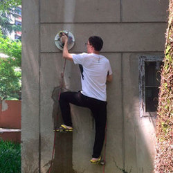 individual using ZPD vacuum suction device to climb a wall