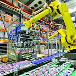 Robotic arms sort and load yogurts onto pallets at a distribution center near Prague, Czech Republic.