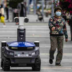 A police security robot in a Shenzhen, China, railway station. Police in China are using surveillance drones to identify people with fevers.