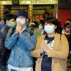 Visitors to a temple in Taipei, Taiwan, wearing surgical masks.