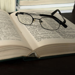 glasses on an open dictionary