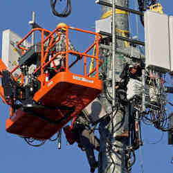 Technicians work on cellular repeaters.