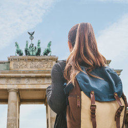 student with backpack at Brandenburg Gate in Berlin