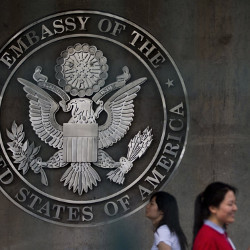 women walk into the visa application section of the U.S. Embassy in Beijing