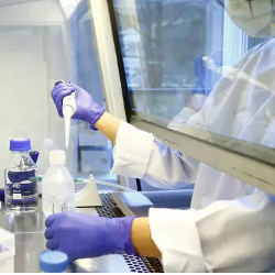 worker in lab with protective shielding