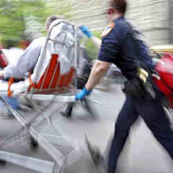 A first responder wheels a patient into a hospital.