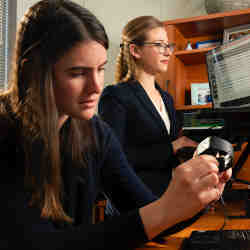 Duke University assistant professor Jessilyn Dunn (right) watches as Dunn's Ph.d. student and co-author Brinnae Bent prepares to download information from a wearable health monitoring device.