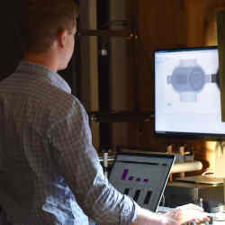 A U.S.-based engineer working from home examines a manufacturing line in China.