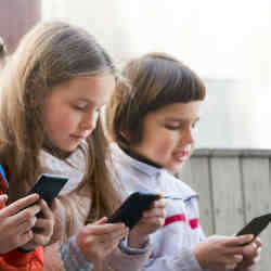 Children playing apps on smartphones. 