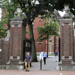 people walking through the gates at Harvard Yard