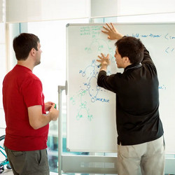 coder at whiteboard explaining his work