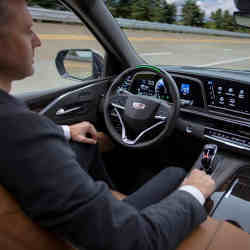 A man behind the steering wheel of a self-driving car.