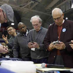 Officials overlook the results of the first referendum count during a caucus event in February at Drake University in Des Moines, IA.