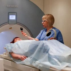 attendant prepares patient for MRI scan