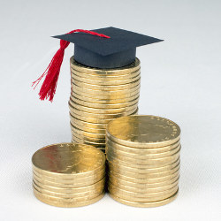 graduation cap and stacks of coins