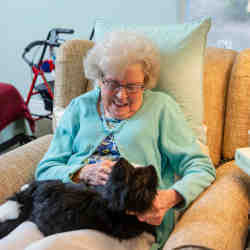 A nursing home resident with a robopet.
