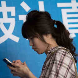 A Chinese woman access the Internet on her phone. 