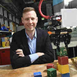 Johns Hopkins University Ph.D. student Andrew Hundt, with block-stacking robot Spot.