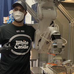 A White Castle team member with Flippy.