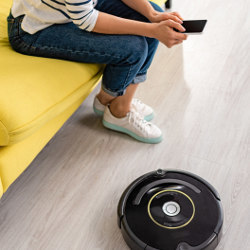 robot vacuum at foot of person using a smartphone