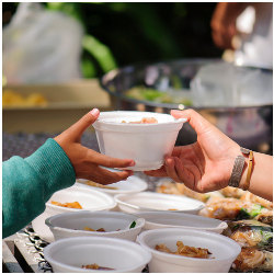 hand passing a bowl of food