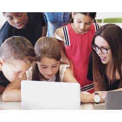 A teacher and her students using a computer for a lession. 