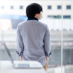 laptop computer on desk as worker looks out the window