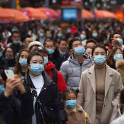 Faces (some masked) in a crowd. 