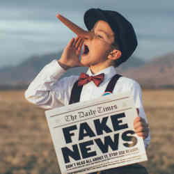 A boy wears a long fake nose (like a lying Pinnochio) while hawking fake news.