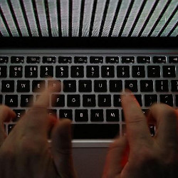 hands typing on a laptop keyboard