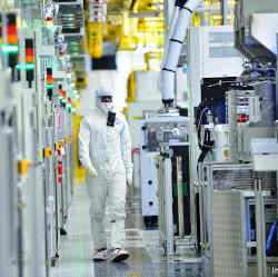 A worker wearing protective gear in an Intel production facility.