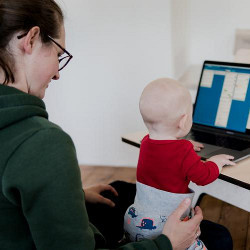 woman with a child on her lap at a computer