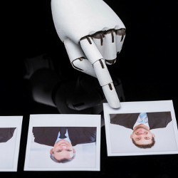 robot hand points to photo of job candidate