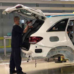 An auto worker assembling a vehicle in a factory operated by Beijing Benz Automotive.