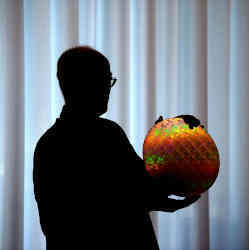 A man holds an etched silicon wafer. 