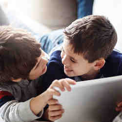 Children access an app on a tablet. 