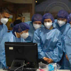 Consulting a computer during a medical procedure. 