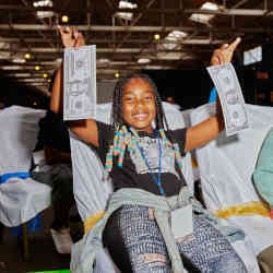 A camper holds up an example of "fiat money" at the Crypto Kids Camp in San Pedro, CA.