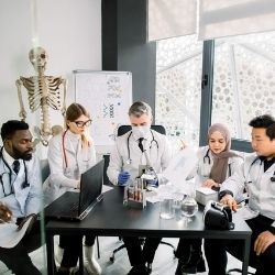 A group of diverse scientists collaborate around a desk