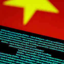 Computer code on a screen next to a Chinese flag.